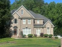 Charming two-story brick home with a well-manicured lawn and mature trees, offering great curb appeal at 3152 Meadow Glade Ct, Lithonia, GA 30038