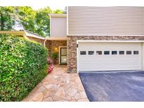 Charming home exterior with stone accents, a well-manicured lawn and an attached two car garage at 41 Basswood Cir, Sandy Springs, GA 30328