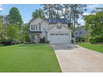 Charming two-story home with a well-manicured lawn and attached two-car garage at 779 Sanders Rd, Cumming, GA 30041