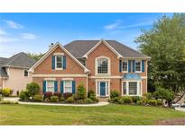 Charming two-story brick home with a manicured lawn, colorful landscaping, and blue shutters at 1274 Ridge Vista Ct, Lawrenceville, GA 30043
