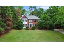 Beautiful two-story brick home with a well-manicured lawn and mature trees at 2005 Sweetgum Trl, Cumming, GA 30041