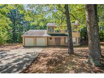 Two-story home featuring a three car garage at 5786 Longbow Dr, Stone Mountain, GA 30087