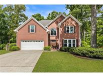 Charming two-story brick home with manicured lawn and a two-car garage, perfect for suburban living at 963 Hawk Creek Trl, Lawrenceville, GA 30043