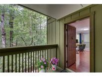 View of balcony with wooded view and freshly painted door leading to living room at 1015 Dunbar Dr, Dunwoody, GA 30338