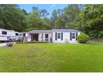 Charming one-story home with a large, well-maintained lawn and a recreational vehicle parked in the driveway at 3184 Newcastle Way, Snellville, GA 30039