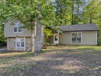 Charming home featuring stone accents, neutral paint, and a welcoming front entrance, nestled among mature trees at 5334 Post Road Pass, Stone Mountain, GA 30088