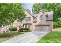Charming brick home with a two-car garage and a well-maintained front lawn and traditional architectural details at 709 Eastwood Rise, Stone Mountain, GA 30087