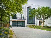 Modern home with a black framed garage door, second story balcony, and neatly landscaped front yard at 2385 Nesbitt Dr, Brookhaven, GA 30319