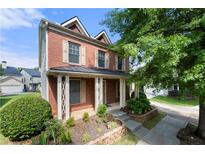 Charming two-story brick home featuring a welcoming front porch, well-maintained landscaping, and inviting curb appeal at 3826 Baxley Village Trl, Suwanee, GA 30024