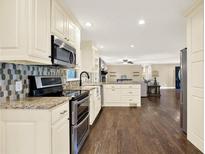 Modern kitchen with stainless steel appliances, granite countertops, and stylish backsplash at 4353 White Oak Dr, Sugar Hill, GA 30518