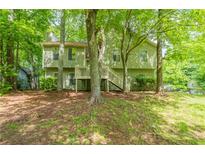 Two-story home surrounded by mature trees and lush greenery, offering a private and serene setting at 6015 Sumit Nw Ct, Kennesaw, GA 30152