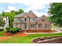 Charming two-story brick home with manicured lawn and mature landscaping at 101 Misty Valley Dr, Canton, GA 30114
