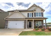 Charming two-story home with stone accents, covered porch, two-car garage, and manicured front yard at 200 Eva Way Ne, Cartersville, GA 30121