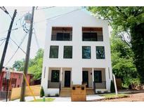 Modern two-story home with white brick, black framed windows, and second story balconies at 262 Crumley St Sw, Atlanta, GA 30312
