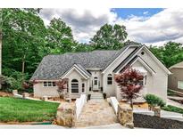 Charming single-Gathering home featuring stone walkway, well-manicured landscaping and a modern roof design at 2682 Boulder Creek Ne Dr, Roswell, GA 30075