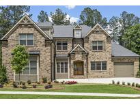 Beautiful brick home featuring a manicured lawn and attached two car garage at 407 Estates View Dr, Acworth, GA 30101