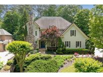 Charming two-story home with a stone chimney and a beautifully landscaped front yard at 4101 Rickenbacker Ne Dr, Atlanta, GA 30342