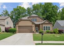 Charming home showcasing a well-manicured lawn, neutral siding, and a convenient two-car garage at 3365 Buffington Ln, Cumming, GA 30040
