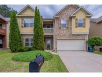 Charming two-story home featuring a stone facade, attached two-car garage and a well-manicured lawn at 3399 Lake Frg, Fairburn, GA 30213