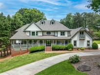 Beautiful two-story home with a brick foundation, lush lawn, large porch, and a circular driveway at 5102 Chastleton Dr, Stone Mountain, GA 30087