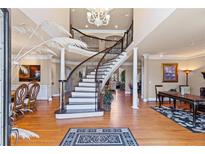 Elegant foyer with a winding staircase, hardwood floors, and a decorative chandelier creates a grand entrance at 2502 Oak Hill Ovlk, Duluth, GA 30097