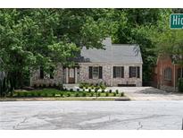 Charming brick home with a well-maintained front yard, lovely landscaping, and a classic roofline at 833 Martina Ne Dr, Atlanta, GA 30305