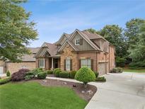 Beautiful brick home with stone accents, lush landscaping, and a three-car garage at 3341 Anna Ruby Ln, Buford, GA 30519