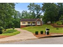 Charming home featuring a manicured front yard, long driveway, and classic architectural details at 670 Dena Dr, Canton, GA 30114