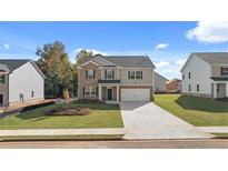 Charming two-story home with a mix of stone and siding, featuring a well-manicured lawn and a paved driveway at 1288 Hollingsworth Way, Dacula, GA 30019