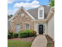 Charming home featuring a stone facade, manicured landscaping, and a welcoming entrance at 1294 Parkview Nw Ln, Kennesaw, GA 30152