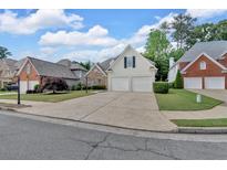 Charming two-story home with a two-car garage, beautiful landscaping, and a concrete driveway at 1294 Parkview Nw Ln, Kennesaw, GA 30152