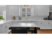 Bright kitchen features white cabinetry, an island with seating, and stainless steel appliances at 1294 Parkview Nw Ln, Kennesaw, GA 30152