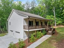 Charming, elevated home featuring a covered porch, two car garage and wooded surroundings at 210 Joe Green Ln, Canton, GA 30114