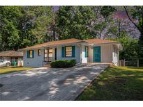 Charming single-story home featuring a well-maintained lawn, updated with vibrant turquoise door and window shutter trim at 2070 Brannen Se Rd, Atlanta, GA 30316
