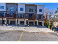Modern townhome exterior with a driveway, individual garages, and small balcony area at 2323 Mason Dr # D21, Atlanta, GA 30316