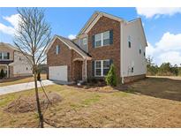 Two-story home showcasing brick and siding with blue shutters and an attached two-car garage at 1246 Allspice Way, Lawrenceville, GA 30045