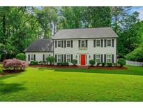 Charming two-story home featuring a bright red front door and a beautifully manicured lawn at 1384 Independence Way, Marietta, GA 30062