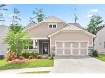 Charming single Gathering home features a 2 car garage, stone accents, manicured lawn, and inviting curb appeal at 169 Hickory Bluffs Pkwy, Canton, GA 30114