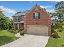 Beautiful two-story brick home with a well-manicured lawn and two car garage at 2430 Tack Hill Ct, Dacula, GA 30019
