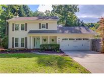 Charming two-story home featuring a well-manicured lawn, two-car garage, and classic curb appeal at 6006 Lanier Heights Cir, Buford, GA 30518