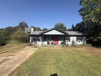 Charming single-story home with a red front door, basketball hoop, and ample green space at 124 Tyler Dr, Mcdonough, GA 30252
