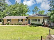 Charming ranch-style home with a well-maintained lawn, mature trees, and a covered parking area at 4820 Yeager Rd, Douglasville, GA 30135
