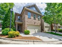 Charming brick two-story home with a two-car garage and landscaped front yard at 2227 W Village Se Ln, Smyrna, GA 30080