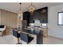 Modern kitchen features a waterfall island, black cabinets, stainless steel appliances and stylish geometric pendant lighting at 1968 8Th St, Chamblee, GA 30341