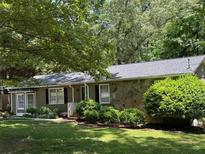Charming single-story home featuring stone accents, a well-kept lawn, and mature trees at 3594 Broxton Ln, Snellville, GA 30039