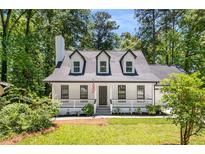 Charming Cape Cod style home featuring dormer windows, a covered front porch, and a landscaped front yard at 944 Pine Ridge Dr, Stone Mountain, GA 30087