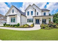 Stunning two-story home featuring a beautifully landscaped yard, covered porch, and classic white siding at 4992 Concert Ln, Marietta, GA 30066