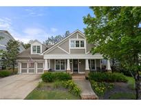 Charming home showcasing a covered front porch, beautiful landscaping, and a two-car garage at 998 Regal Hills Ln, Mableton, GA 30126