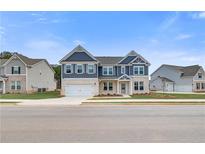 Beautiful two-story home featuring a white brick facade and complementary blue toned siding under a bright, clear sky at 242 Linford Dr, Locust Grove, GA 30248