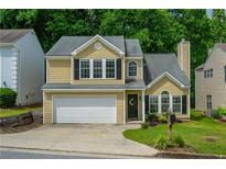 Two-story home featuring a two-car garage, and neutral siding, surrounded by well-maintained landscaping at 3454 Benthollow Ln, Duluth, GA 30096